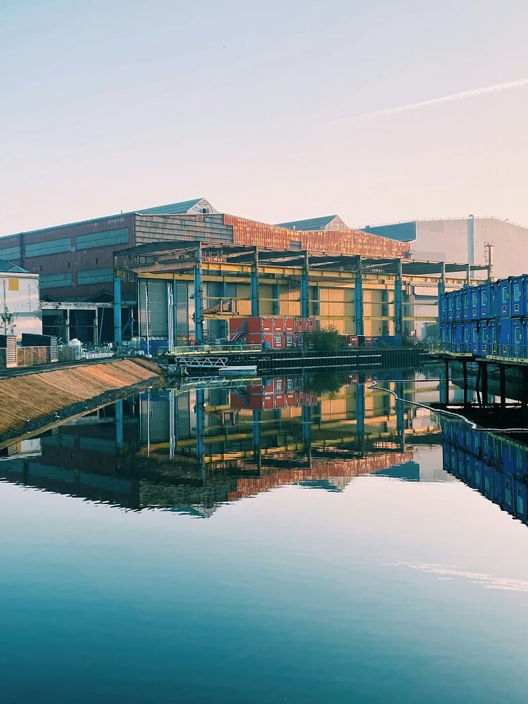 Usine industrielle avec bassin d'eau, illustrant les enjeux de l'optimisation de la consommation d'eau industrielle